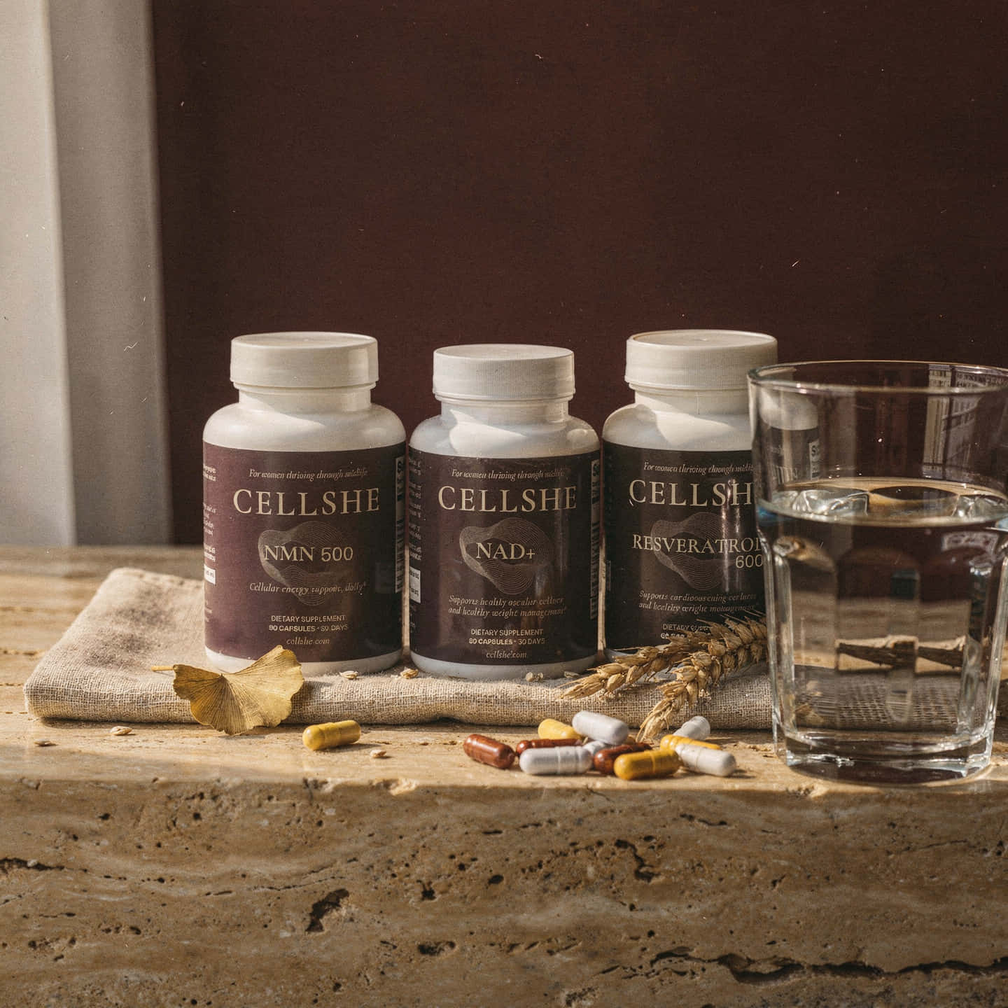CELLSHE NMN 500, NAD+, and Resveratrol 600 bottles with capsules and water for a daily longevity routine