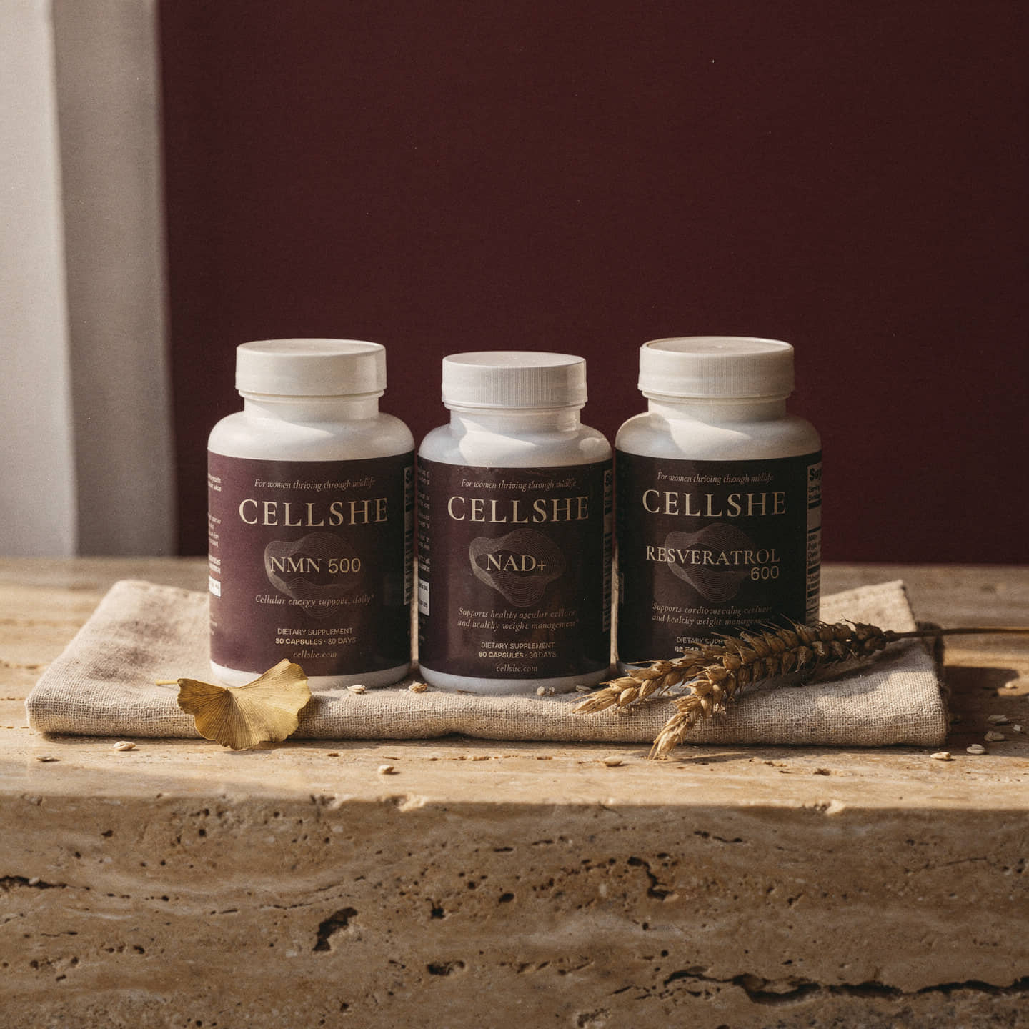 CELLSHE Cellular Trio with NMN 500, NAD+ and Resveratrol 600 bottles on a rustic stone surface